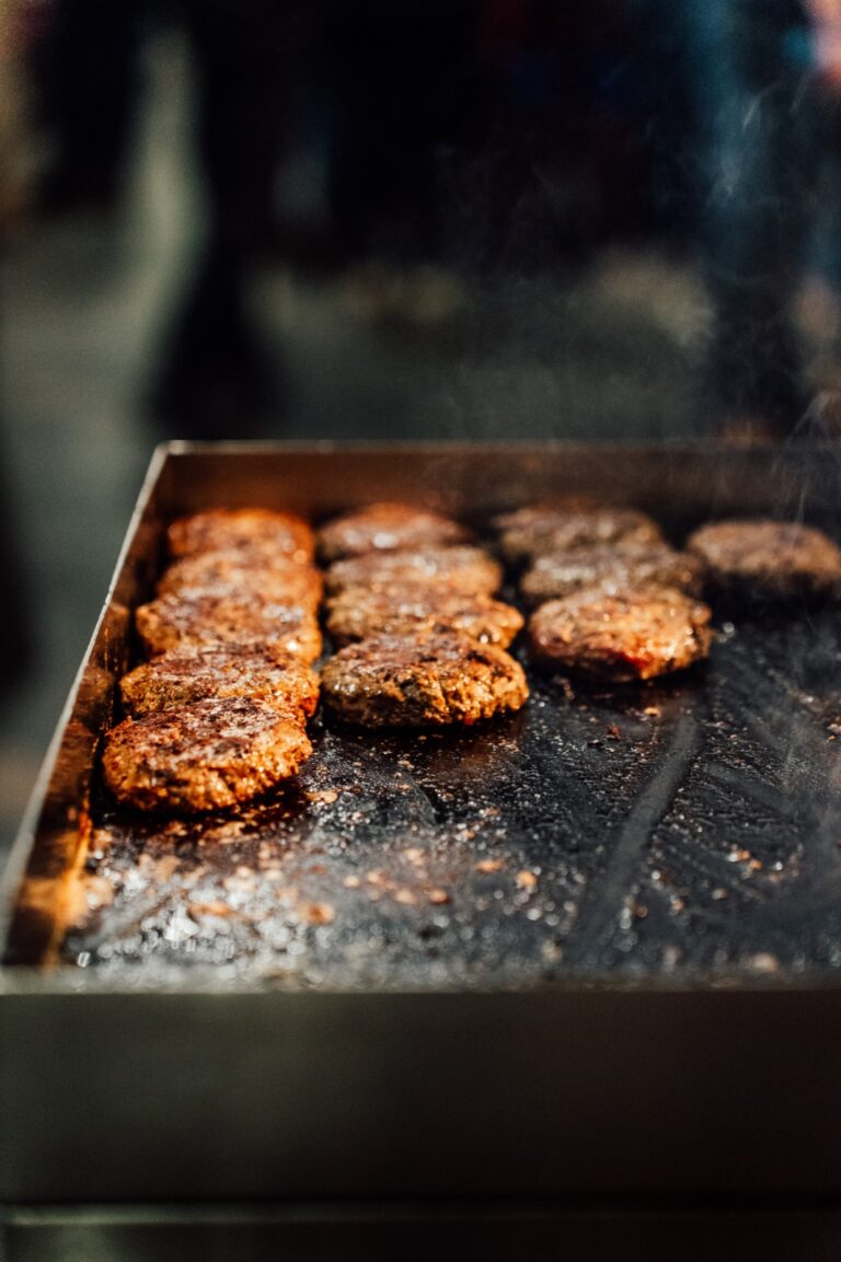 Des hamburgers cuisent sur la plaque de cuisson