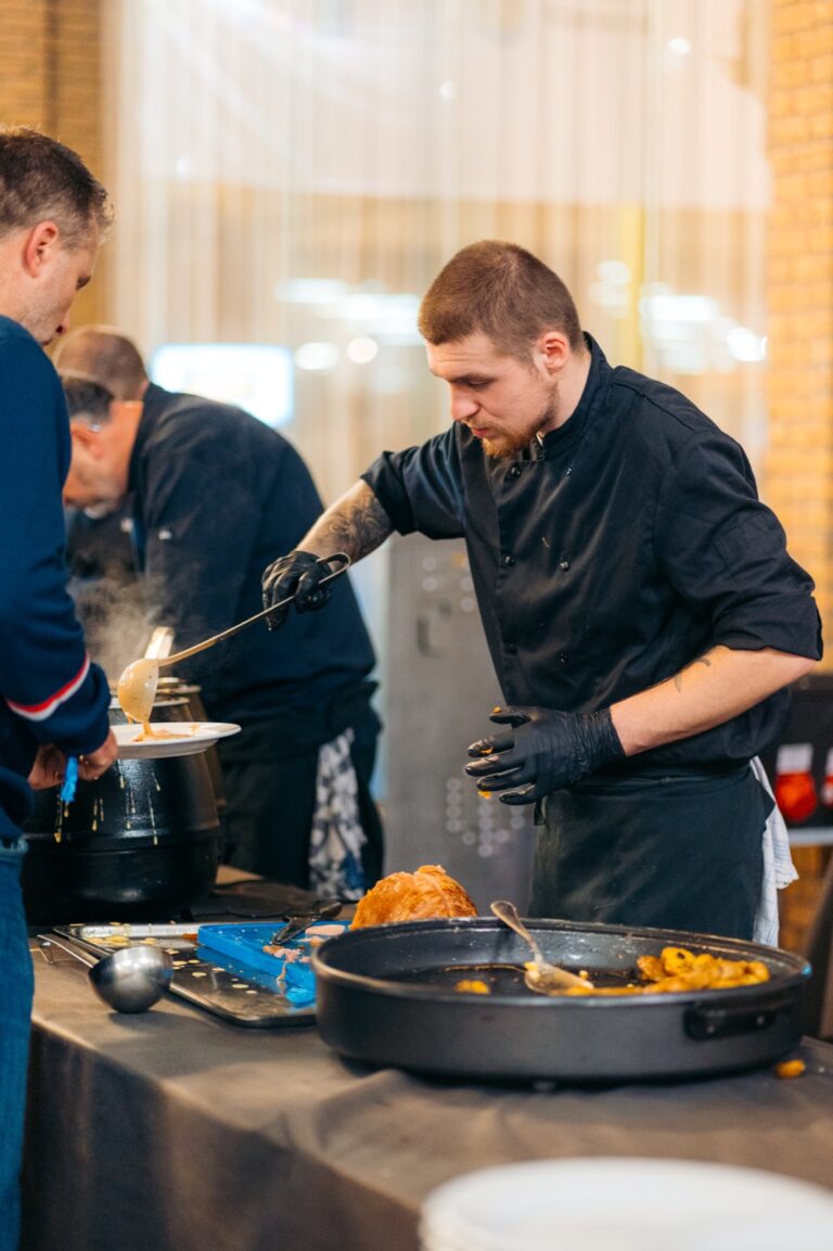 Un cuisinier sert la sauce au buffet